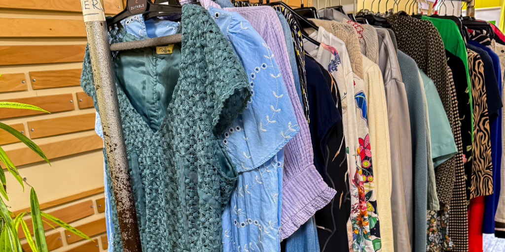 Goedgevulde kledingrekken in het Infopunt