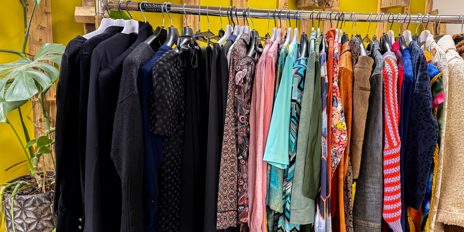 Goedgevulde kledingrekken in het Infopunt