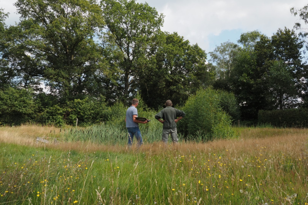 overleg bij een poel in het weiland