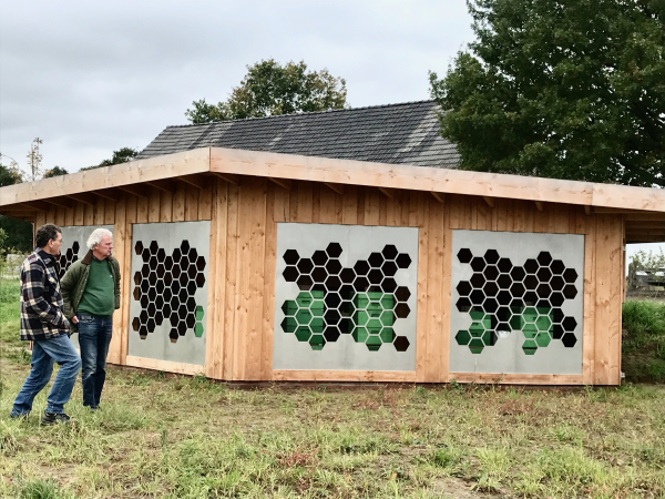 Design bijenstal: door de honingraatgaten in metaal, vliegen de bijen naar de kasten.